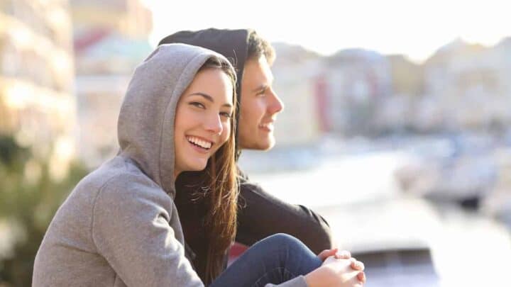 young woman and man close to each other in a beach town overlooking the beach area, Beach Towns For Young Adults: The Best Places To Live On The Beach