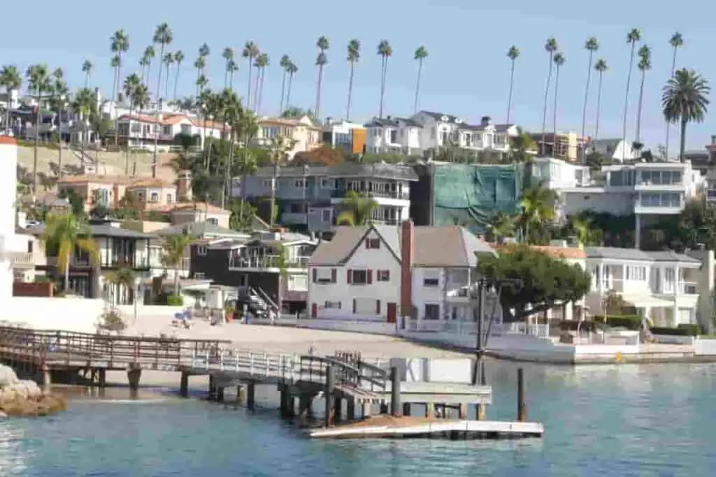 view of newport beach california with palm triees and houses near the beach and harbor, Beach Towns For Young Adults: The Best Places To Live On The Beach, cheapest beach towns in florida, best beaches for young adults, best beach towns to live in for young adults, best beach towns for young adults, best beach towns in florida to live for young adults, best beaches in florida for singles, best beach towns for young single adults, best places for young singles to live
