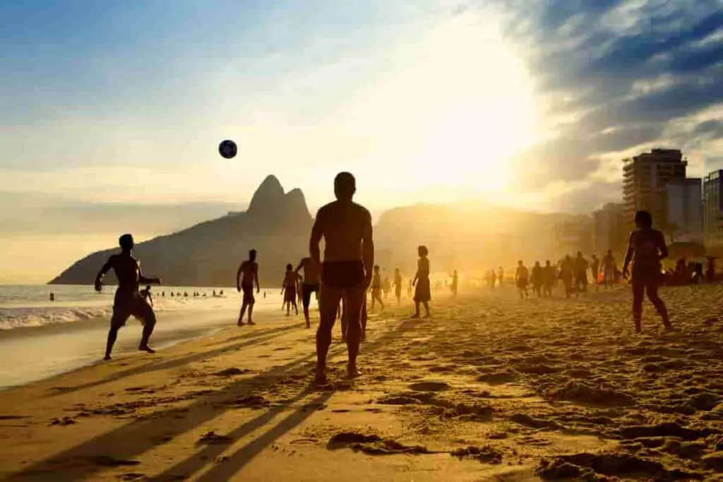 sunset beach photography with people playing ball on the beach