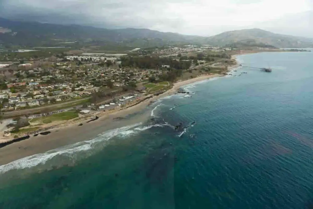 aerial view of the coast with land on the left and blue water on the right, Towns Near Santa Barbara With a Beach - 9 [Charming] Nearby Towns in California, towns near santa barbara, cities near santa barbara, best beaches in santa barbara, santa barbara beaches, small towns near santa barbara, town near santa barbara, towns near santa barbara california