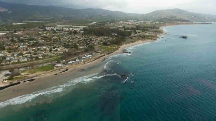 aerial view of the coast with land on the left and blue water on the right, Towns Near Santa Barbara With a Beach - 9 [Charming] Nearby Towns in California
