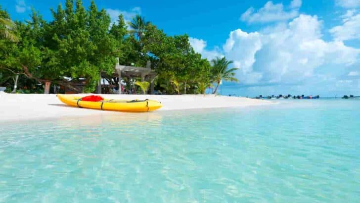 rubber craft on beautiful white sand with aqua blue water with trees in the background, 9 Colombian Beach Towns- [Surprising Beautiful] Caribbean Coast Cities With Beaches in Colombia