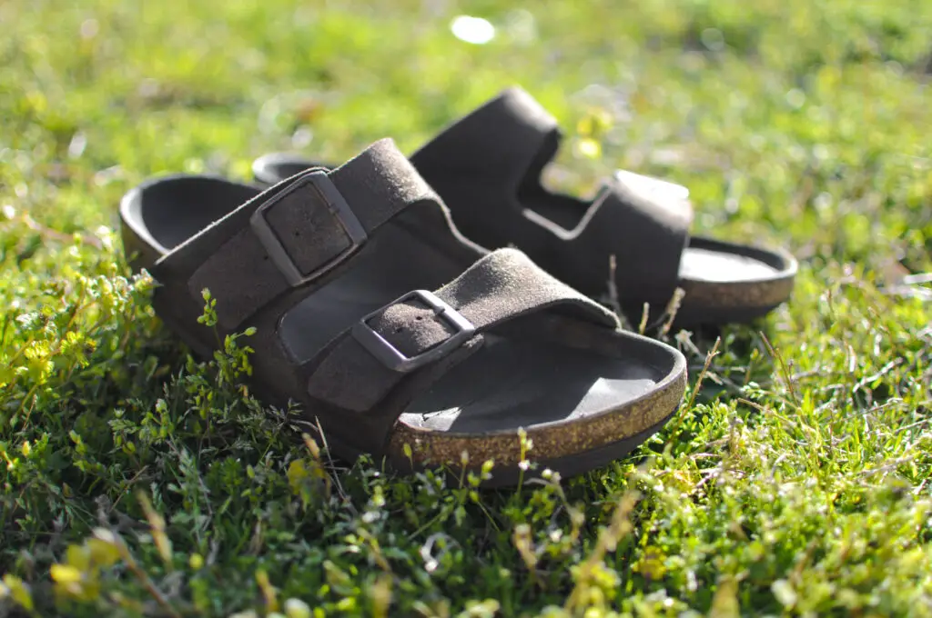 brown leather sandals on green grass, Experience Comfort: Unveiling the Best Beach Sandals For Men, best beach footwear, beach sandals for men, best sandals for men, men's sandals, beach thong sandals for men, active beach footwear, beach sandals for sand, water beach sandals