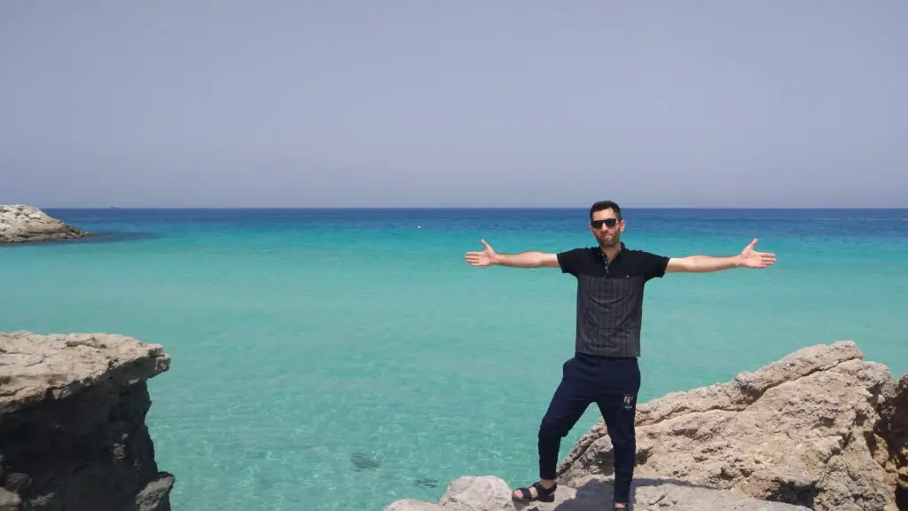 man in black t-shirt standing on rock near sea during daytime, 21 [Best] Beach Photo Ideas for Guys- Poses Make The Difference, Action Shots on Beach, beach pictures poses man, beach pose ideas, Mens Beach Poses, beach poses man, beach poses for men, beach photo ideas for guys