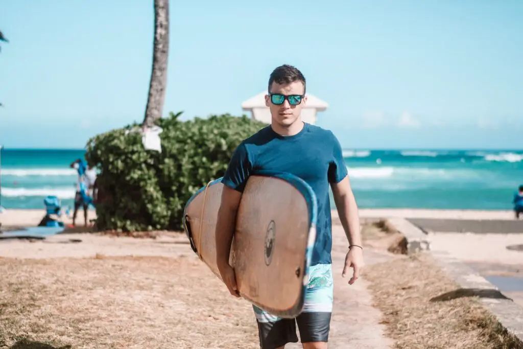 man in blue crew neck t-shirt and brown shorts standing on brown sand during daytime, 21 [Best] Beach Photo Ideas for Guys- Poses Make The Difference, beach pose ideas, beach pictures poses man, beach poses man, Action Shots on Beach, beach photo ideas for guys, Mens Beach Poses, beach poses for men