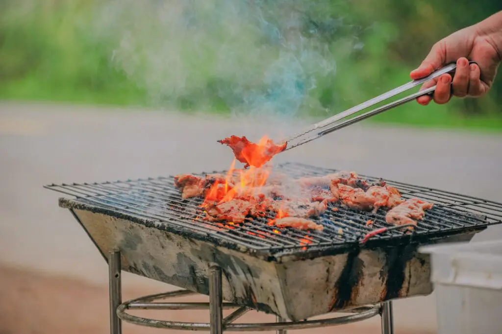 Person Holding Tongs Ccoking Barbecue, How to Grill on The Beach: Surprising [Simple Methods] To Prepare Food For Your Beach BBQ, can you cook on the beach, can you grill on the beach, can i grill on the beach, grilling on the beach, how to grill on the beach, grill on the beach, how to grill on the beach
