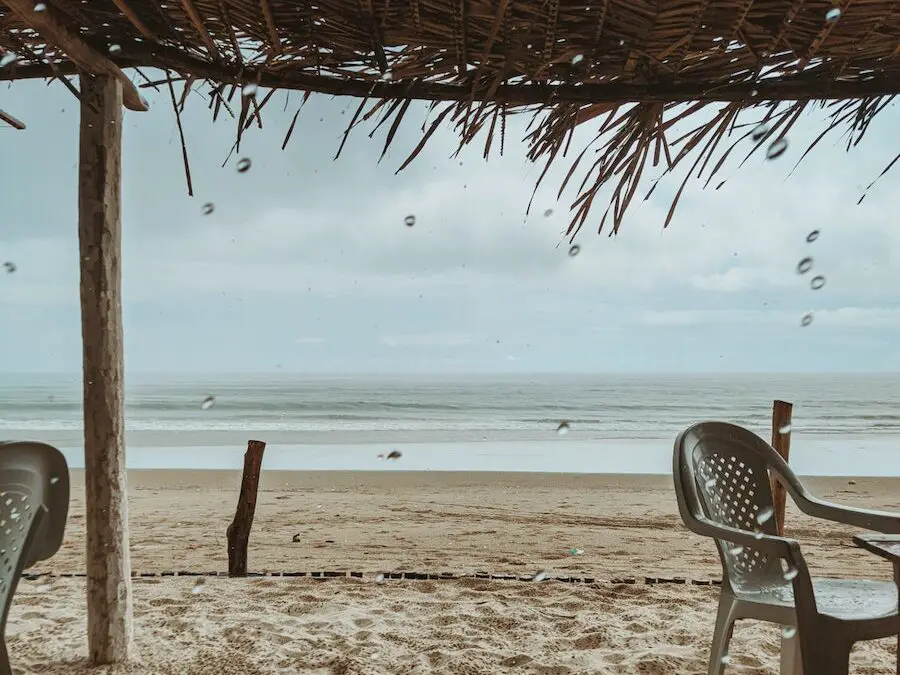 Raindrops Falling on beach while in a beach shack overlooking the beach and the surf, Making the Most of a Rainy Day at the Beach: Fun Rainy Day Activities to Enjoy Despite the Weather, what to do at the beach when it rains, rainy day beach activities, rainy day at the beach, rainy beach day, beach in the rain, rainy beach, rainy day beach activities
