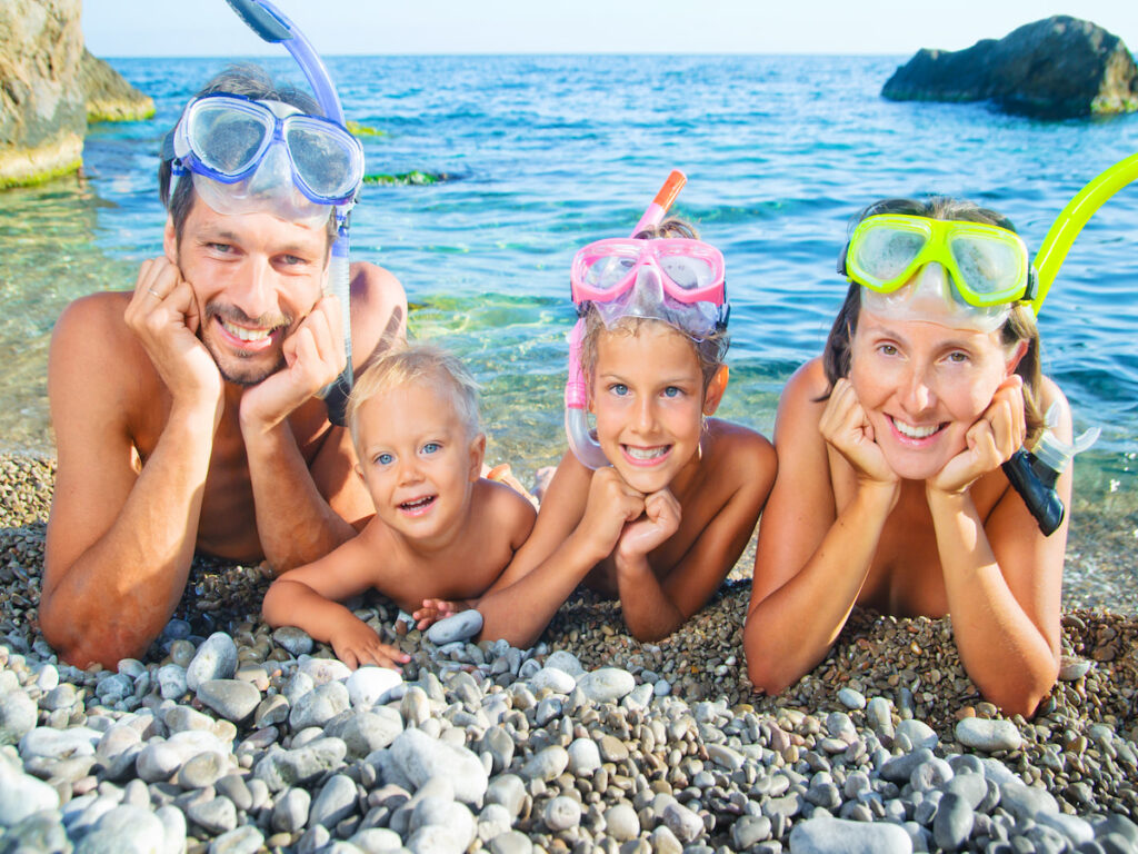 a family in snorkel gear smiling and ready to go snorkeling, Best Snorkeling for Families- Amazing Travel Destinations [Beaches, Beginners, Caribbean], best snorkelling holidays for families, best snorkeling for families, best snorkeling places in Croatia, places for snorkeling in Croatia, best snorkeling in Europe, best places to snorkel, family snorkeling